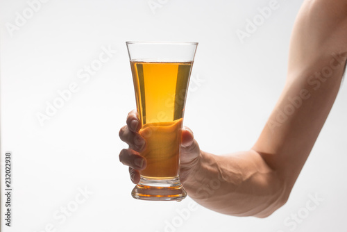 Hand holding glass of craft beer on white background