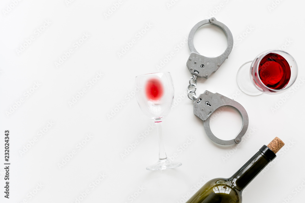 Illegal sale of alcohol concept. Handcuffs near wine glass and bottle on white background top view copy space