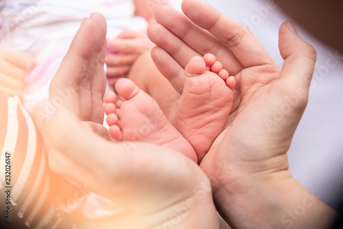 Baby feet into mothers hands.Baby feet into mothers hands. Happy Family concept. Beautiful conceptual image of Maternity