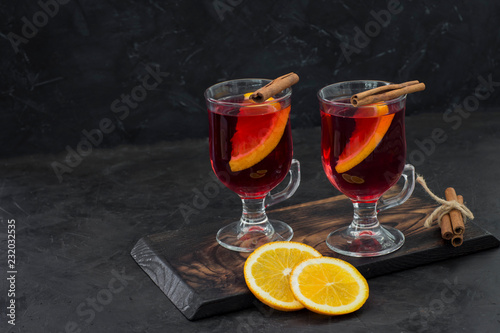 hot red drink in transparent circles with cinnamon and orange - hot wine, mulled wine, grog, tea with orange