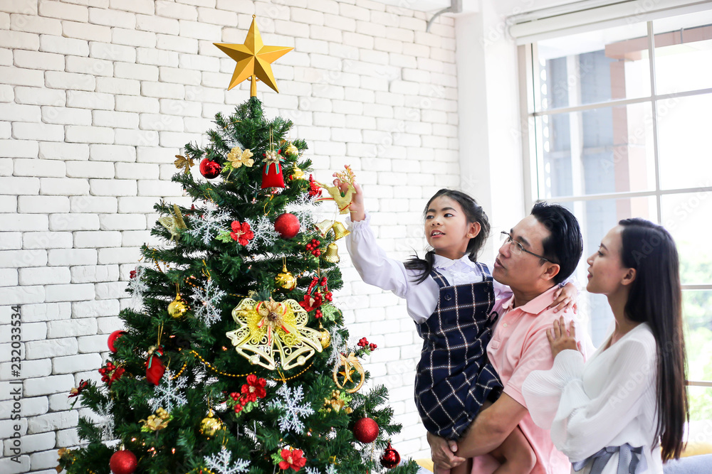 Family decorating a Christmas tree and Father giving Christmas Gift,Christmastime celebration and Happy new year. Family decorating a Christmas tree and Father giving Christmas Gift,Christmastime celebration and Happy new year.