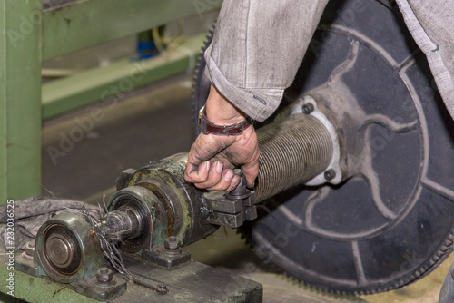 A mechanic repairs a machine in a factory. photo