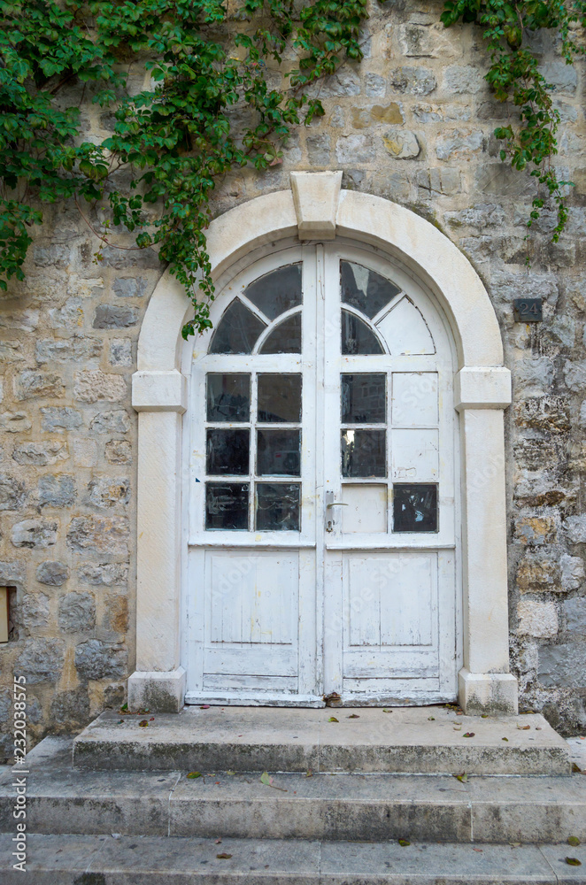 Fototapeta premium Old, glass, paneled white wooden door in the old building.