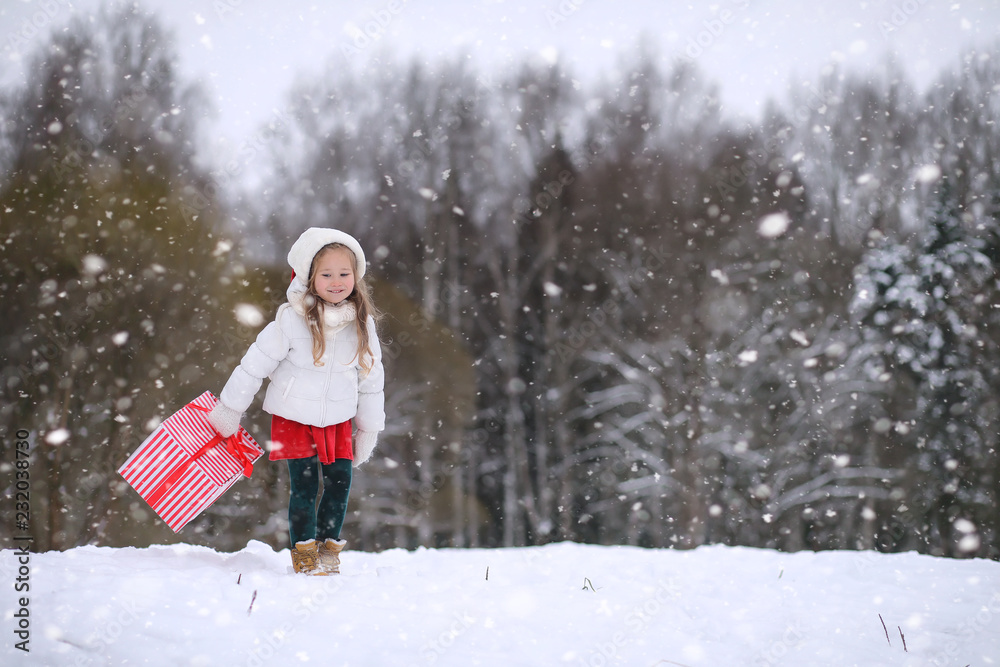 A winter fairy taleA girl on a sled with gifts on the eve of the new year in the park. Two sisters walk in a New Year's park and ride a sled with gifts.