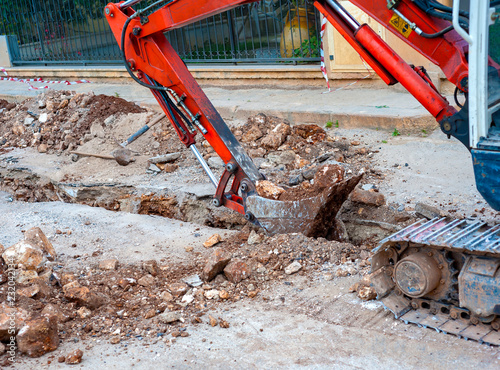 excavation with a narrow section to bury corrugated plastic cable ducts for the production of a fiber optic telecommunication cable distribution network.
