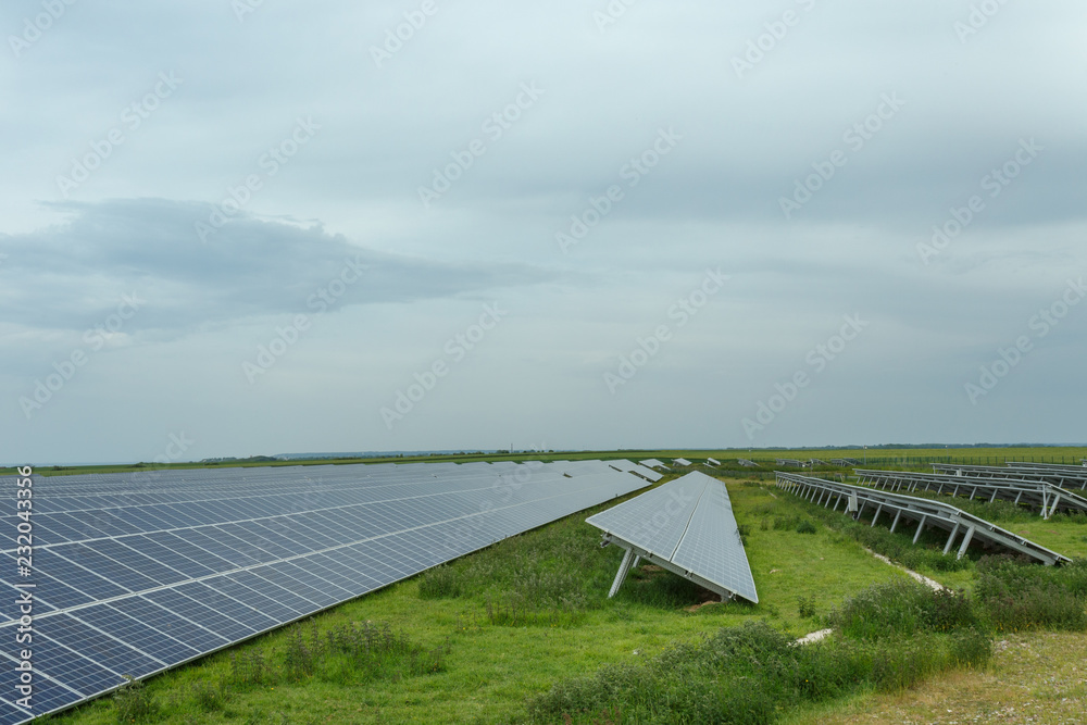 Solar panels on a cloudy day in Normandy, France. Solar energy, modern electric power production technology, renewable energy concept. Environmentally friendly electricity production