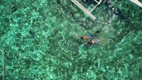 Aerial view of two people snorkeling in turquoise water in Panagsama Beach, Philippines. photo