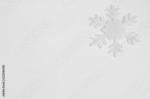 White felt snowflakes on a white background.