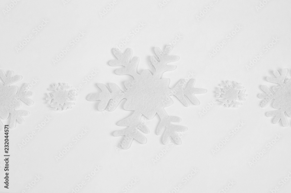 White felt snowflakes on a white background. White felt snowflakes on a white background.