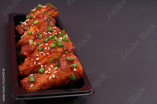 Korean fried chicken with black backdrop.