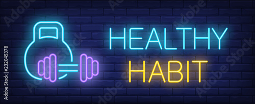 Healthy habit neon sign. Glowing inscription with kettle bell and barbell on dark blue brick background. Can be used for topics like fitness, gym, active lifestyle
