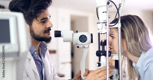 Patient or customer at slit lamp at optometrist or optician photo