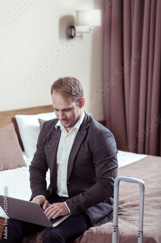 Handsome businessman wearing white shirt and suit sitting in hotel