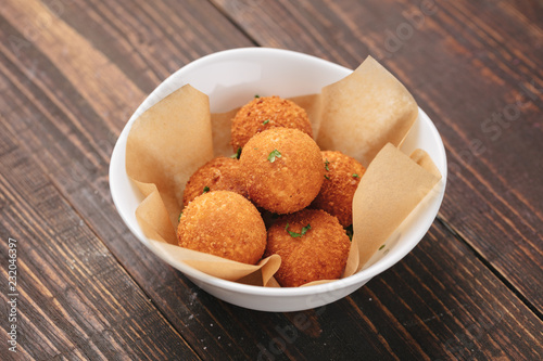 Fried potato balls served on a white plate as beer snack