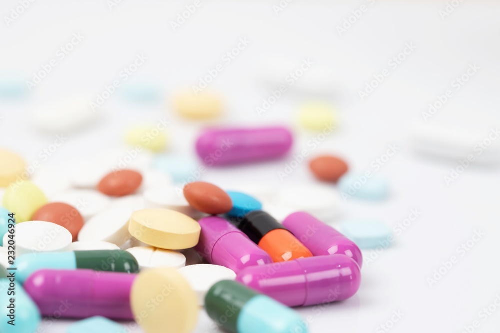 close up macro Pill spilling out disrupted. colorful pills capsule on to surface tablets on a white background. drug medical healthcare concept. close up macro Pill spilling out disrupted. colorful pills capsule on to surface tablets on a white background. drug medical healthcare concept.