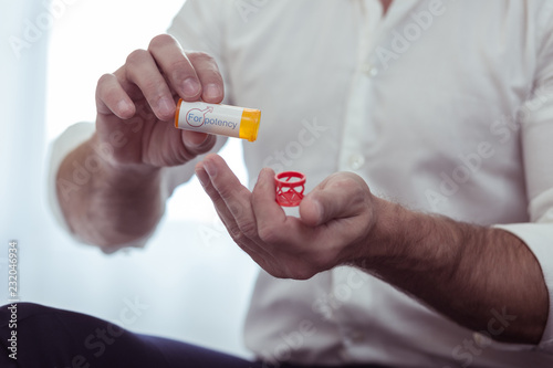 Businessman wearing white shirt drinking pills for potency