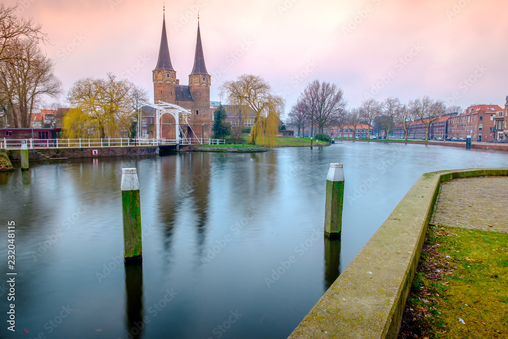 Naklejka premium Evening view of the canal and the VVE Oostpoort de Delft. Dutch city in the spring after sunset. Holland, Netherlands.