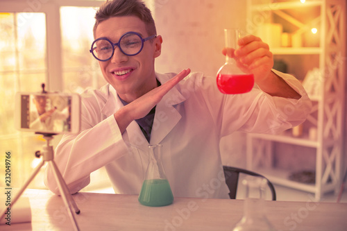 Beaming chemist holding test tube in one hand