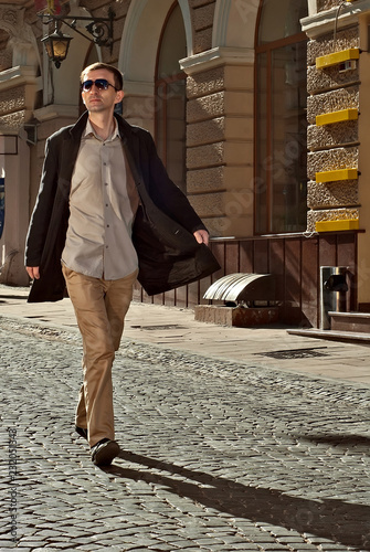 A man walks down the street of the old city. Kobylianska street, Chernivtsi, Ukraine, Europe. photo