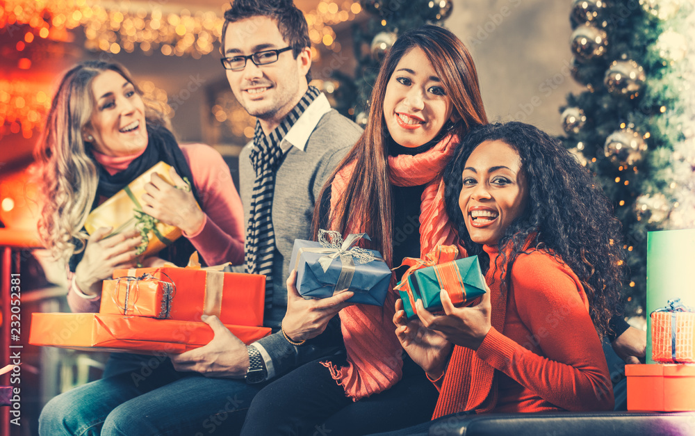 Obraz premium Diversity Friends with Christmas presents and bags shopping in mall with light decoration