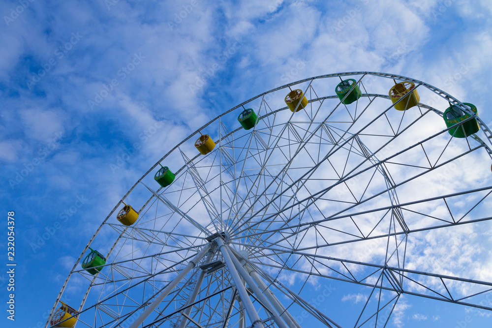 big Ferris wheel against blue sky with clouds big Ferris wheel against blue sky with clouds