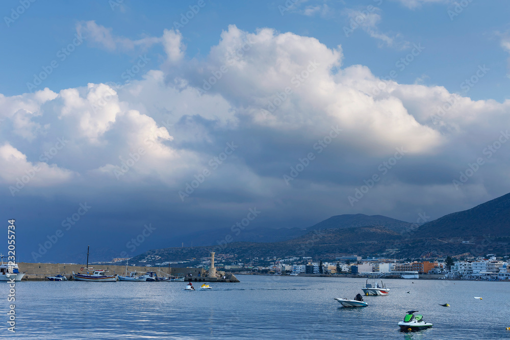 Fototapeta premium small and large motor boats in the harbor on against a cloudy sky background