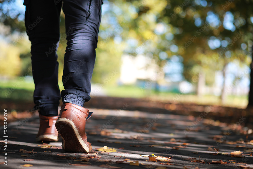 Autumn Park man walking along a path foliage Autumn Park man walking along a path foliage