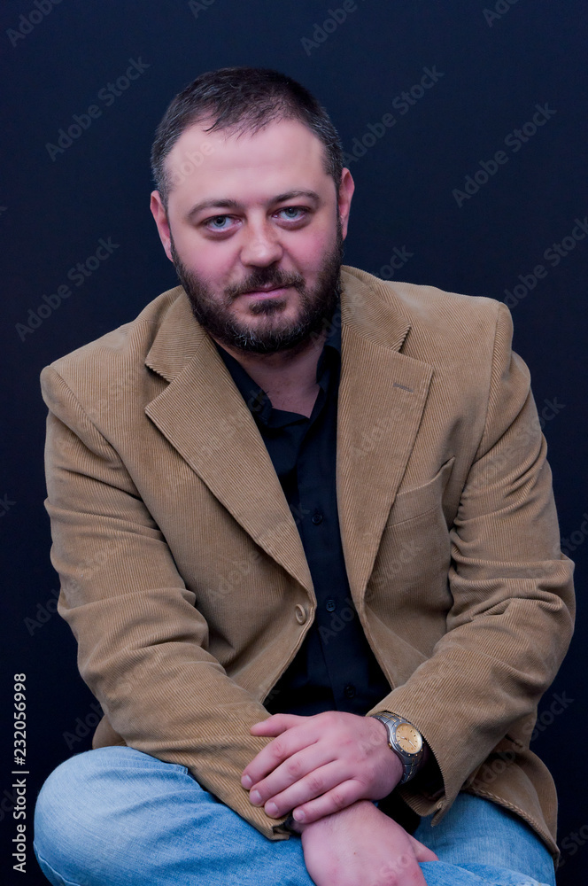 Fototapeta premium Portrait of sitting man with yellow jacket and black shirt