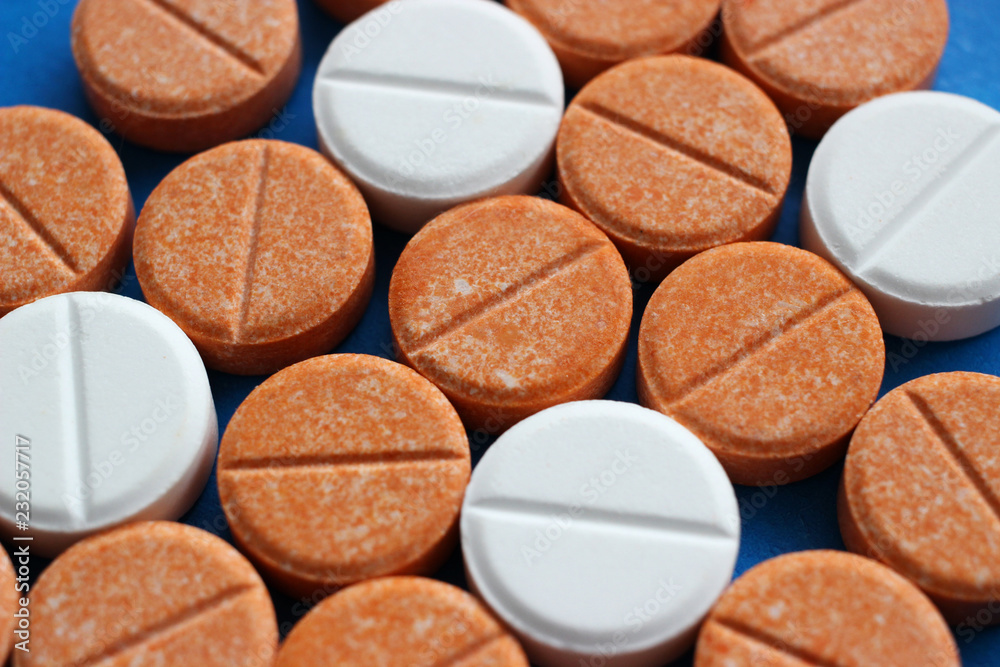 Orange and white tablets of glucose and vitamin c. Orange and white tablets of glucose and vitamin c.