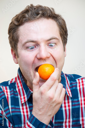 Man trying to swallow whole tangerine photo