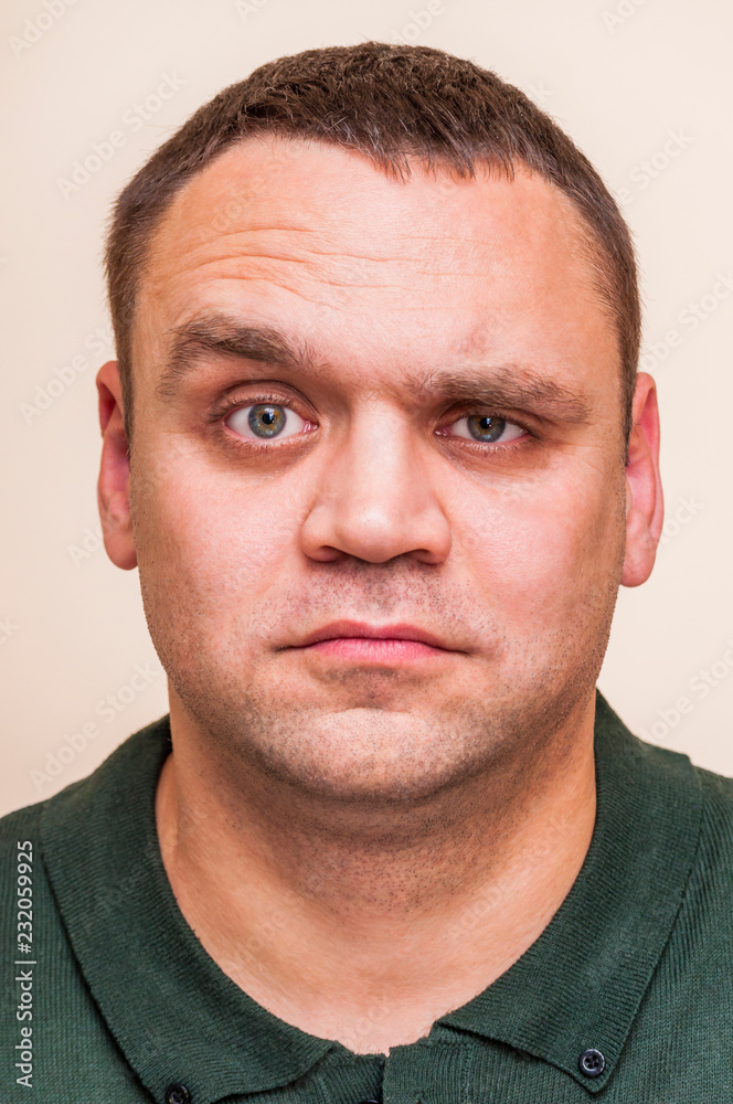 Obraz premium Young man questionably, mistrustfully looking with raised eyebrow