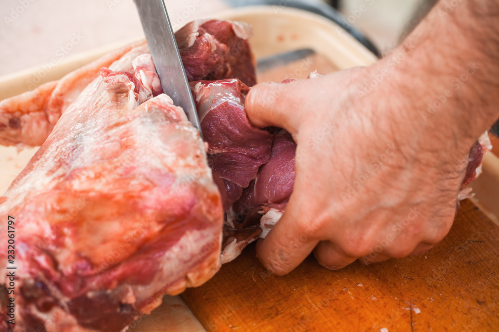 Lamb cutting, cook hands with knife