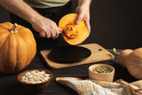 The cook separates the grain from the pumpkin cut in half.