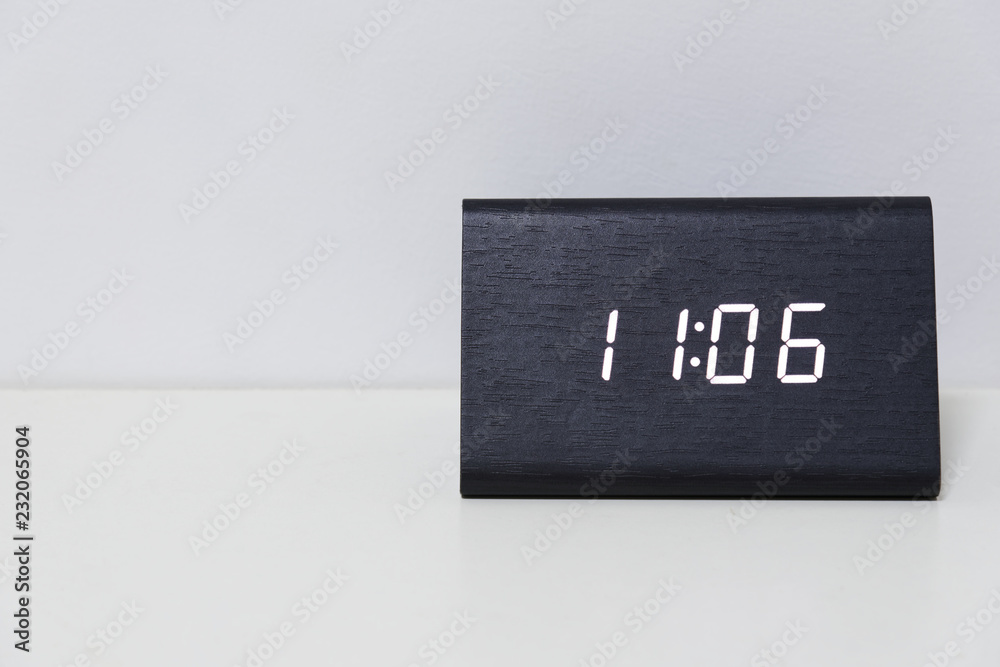 Black digital clock on a white background showing time 11:06 Black digital clock on a white background showing time 11:06