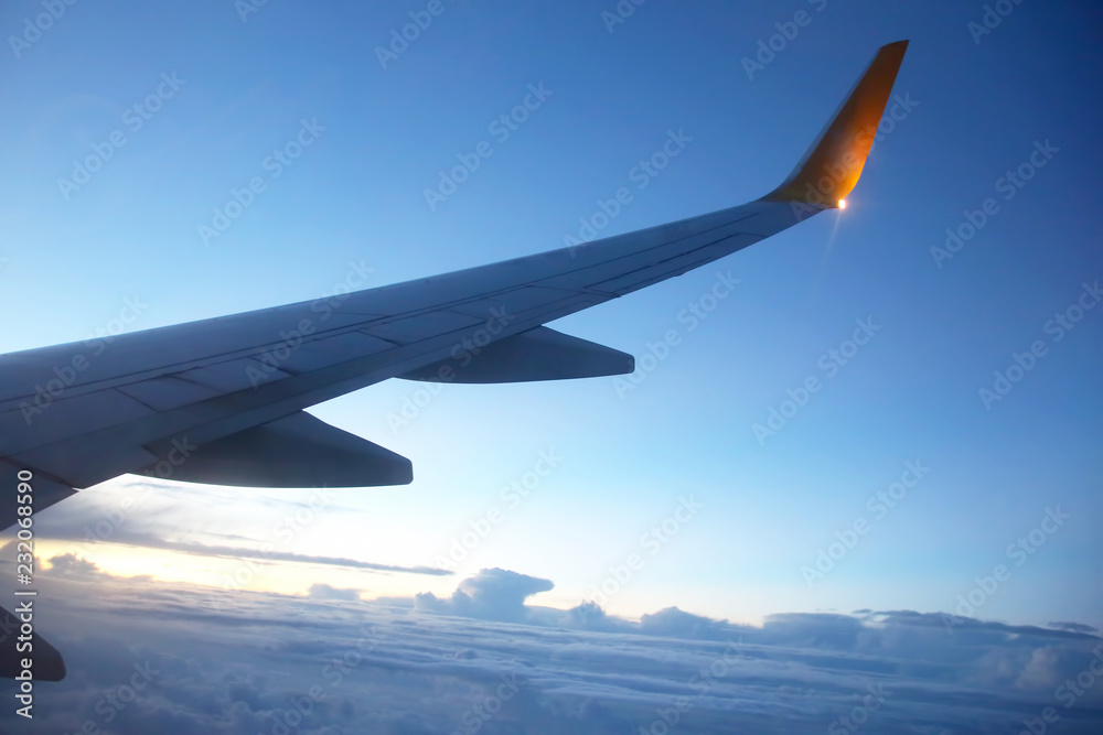 Fototapeta premium Wing passenger aircraft in flight over the evening clouds