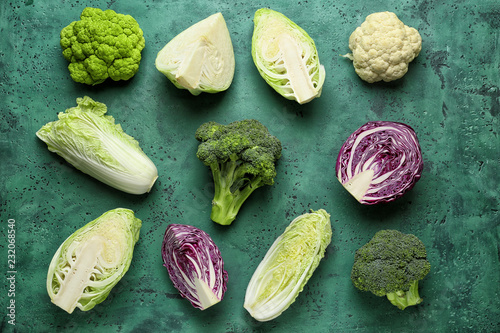 Different kinds of cabbage on color background photo