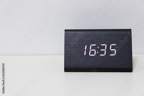 Black digital clock on a white background showing time 16:35 photo