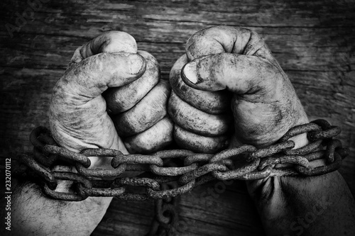 Fotografía Powerful dirty male hands clenched into fists chained with rusty chain