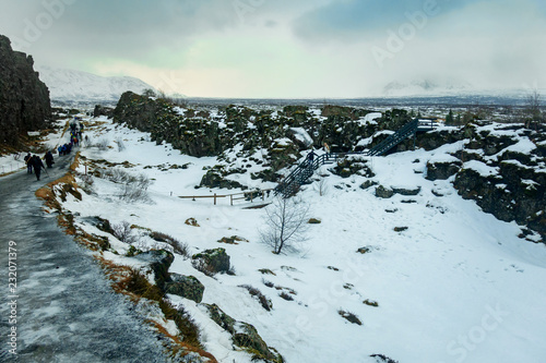 Þingvellir National Park, on a cold, wintry day, with people walking the pathway.