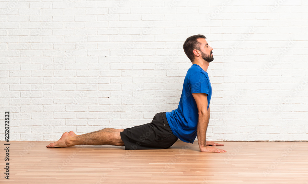 Fototapeta premium Man doing yoga exercises indoors