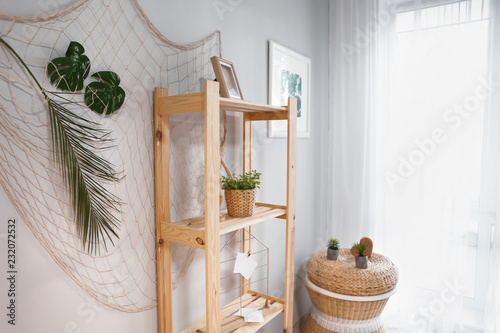 Shelving unit with green plant and decor in room