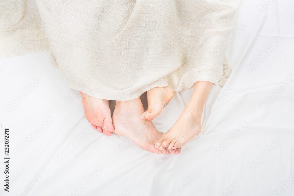 Close-up of the feet of a couple on the bed Close-up of the feet of a couple on the bed