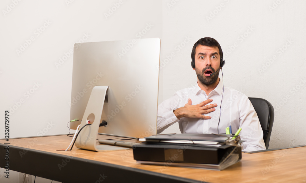 Telemarketer man in a office surprised and shocked while looking right Telemarketer man in a office surprised and shocked while looking right