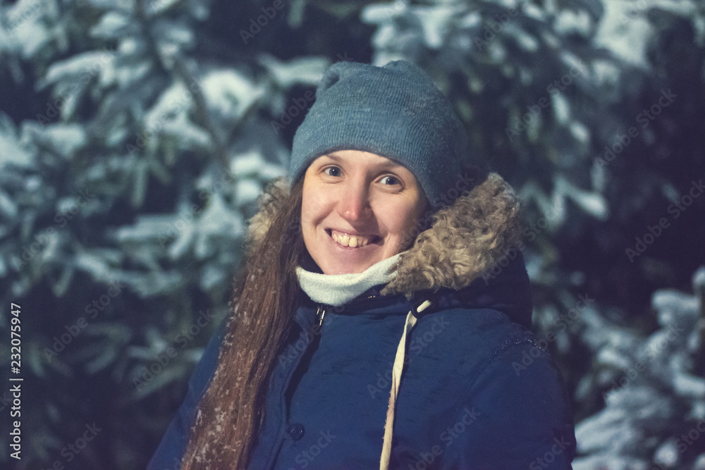 Girl at night on a background of snow-covered trees in winter Girl at night on a background of snow-covered trees in winter