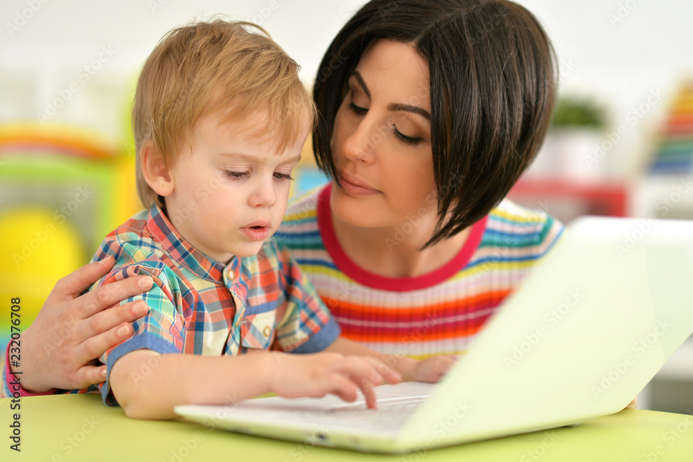 Close up portrait of mother and son sitting at table Close up portrait of mother and son sitting at table