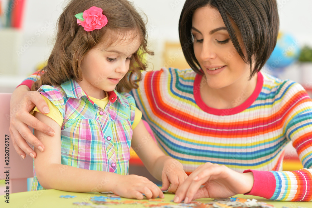 Fototapeta premium Close up portrait of young mother playing with little daughter