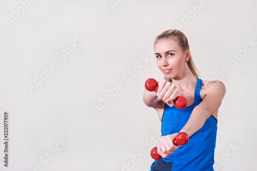 Female athlete doing exercise with dumbbell. Copy space. Concept of health and body care.