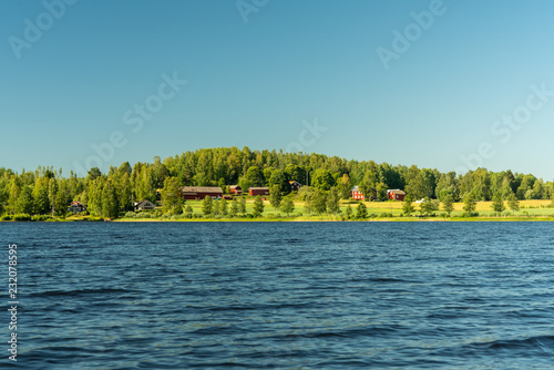 Typical Swedish countryside farm by a lake in beautiful summer sunshine