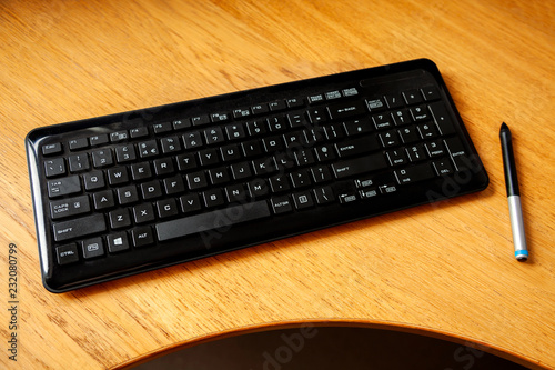 Generic keyboard on a desk with a pen