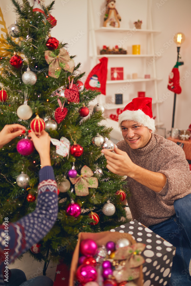 Happy couple decorating tree for New Year's / Christmas eve. Happy couple decorating tree for New Year's / Christmas eve.